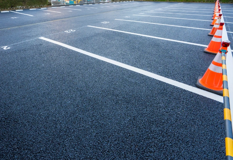 Završen parking prostor nakon asfaltiranja sa ravnom površinom spremnom za obeležavanje parking mesta.